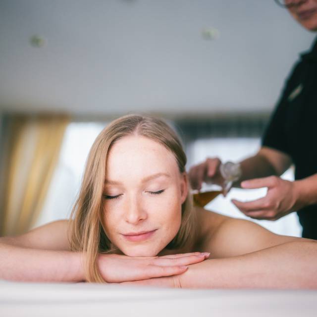 Frau auf Massage Liege erhält Kosmetik Behandlung