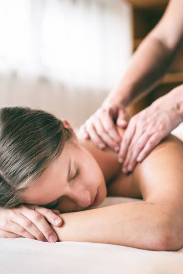 Frau erhält Rückenmassage