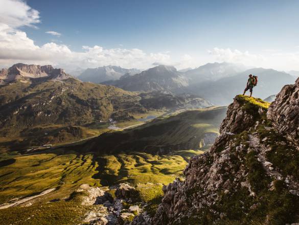 Bergwanderer auf Gipfel blickt auf Tal