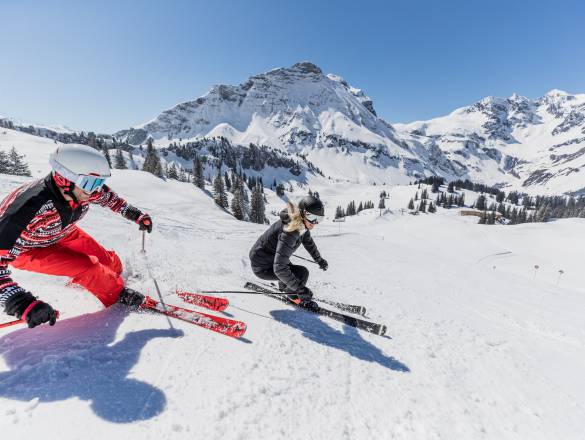 Skifahrer fahren die Piste vom Arlberg runter 