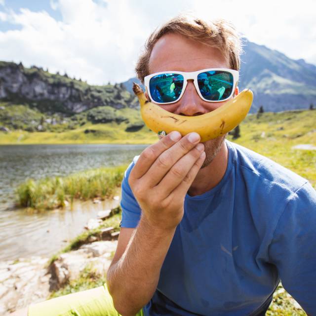 Mann hält Banane vors Gericht als Lächeln