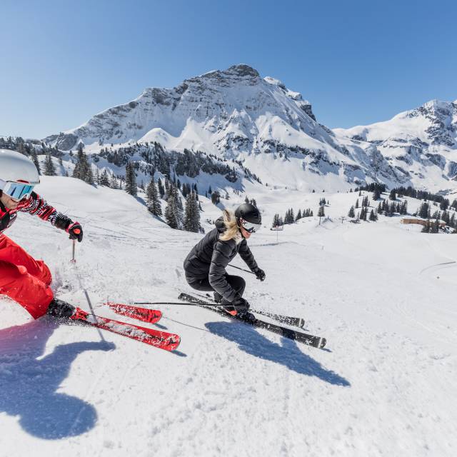 Skifahrer fahren die Piste vom Arlberg runter 
