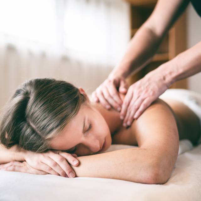 Frau erhält Rückenmassage