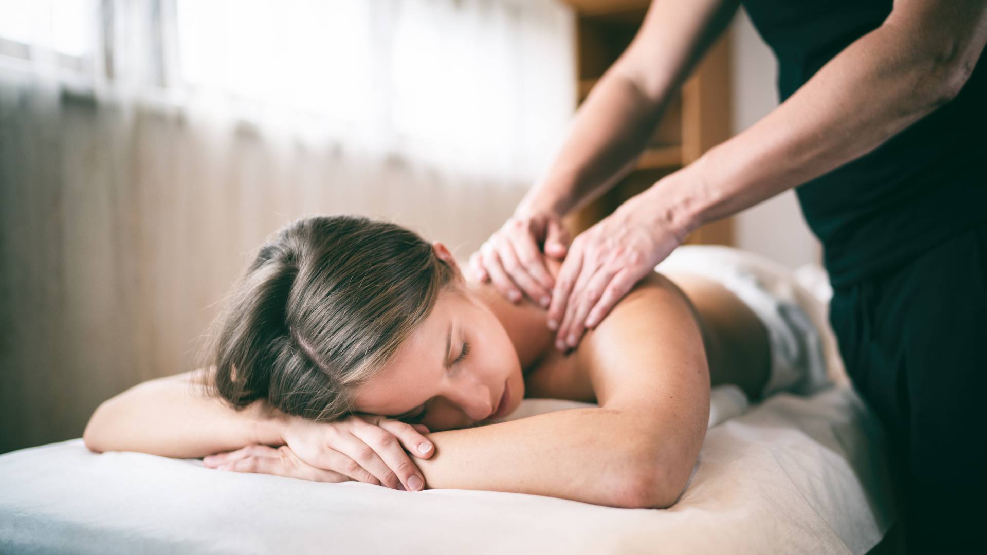 Frau erhält Rückenmassage